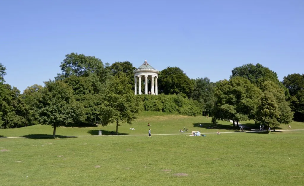 Monopteros temple in the English Garden, Munich, surrounded by green lawns and trees under a clear blue sky