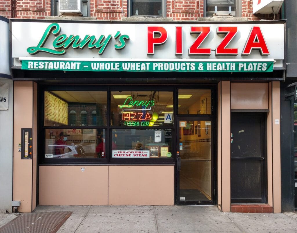 Lenny's Pizza restaurant storefront in Brooklyn, NY, with a neon sign and signage promoting whole wheat products and health plates