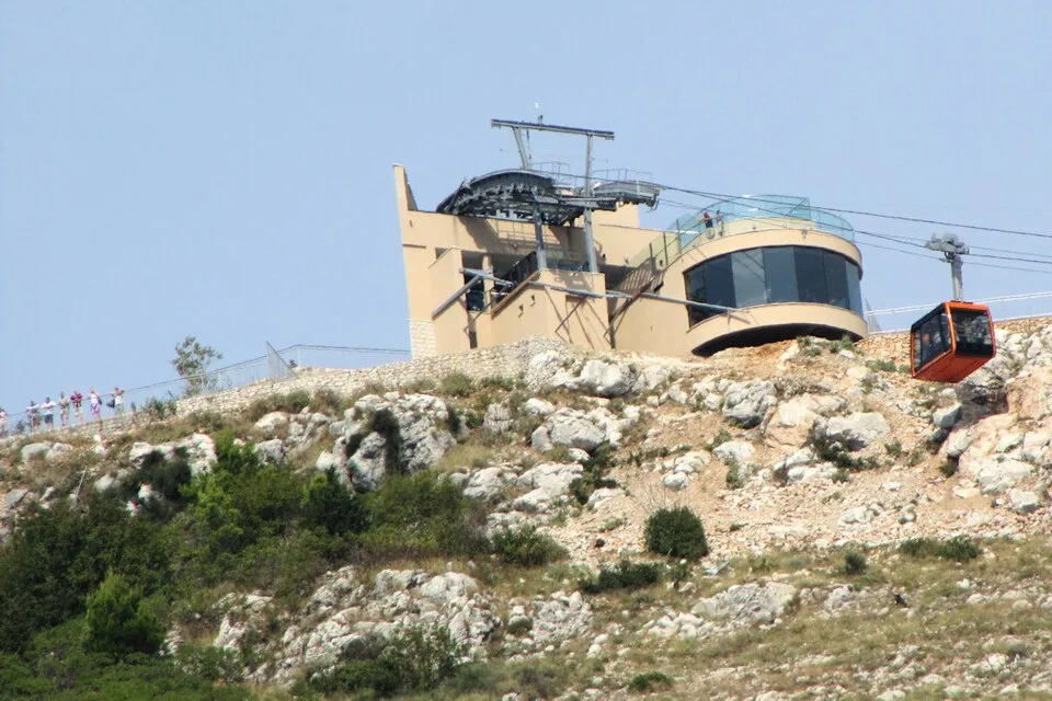The Dubrovnik Cable Car arrives at the upper station on Mount Srđ, which has a rocky hillside and panoramic viewpoints.