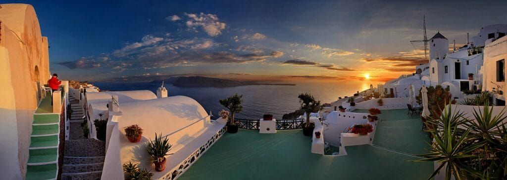 Breathtaking sunset view over the Santorini Caldera from a cliffside viewpoint in Oia, Greece
