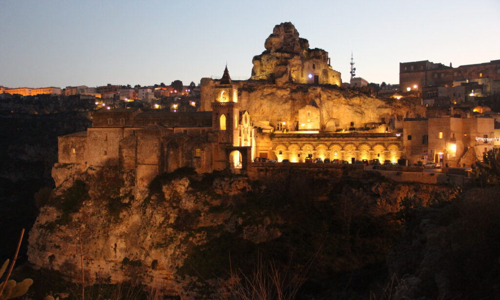 hurch on the cliff edge overlooking the Gravina Canyon in Matera Italy]