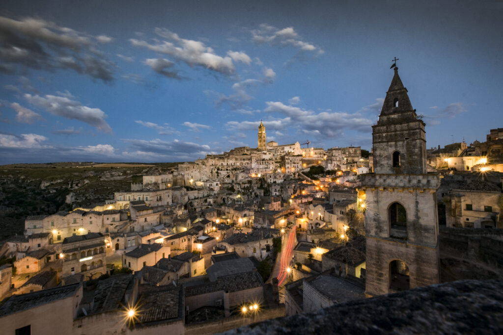 panoramic view of Sassi di Matera with stone houses and caves at sunset Italy]