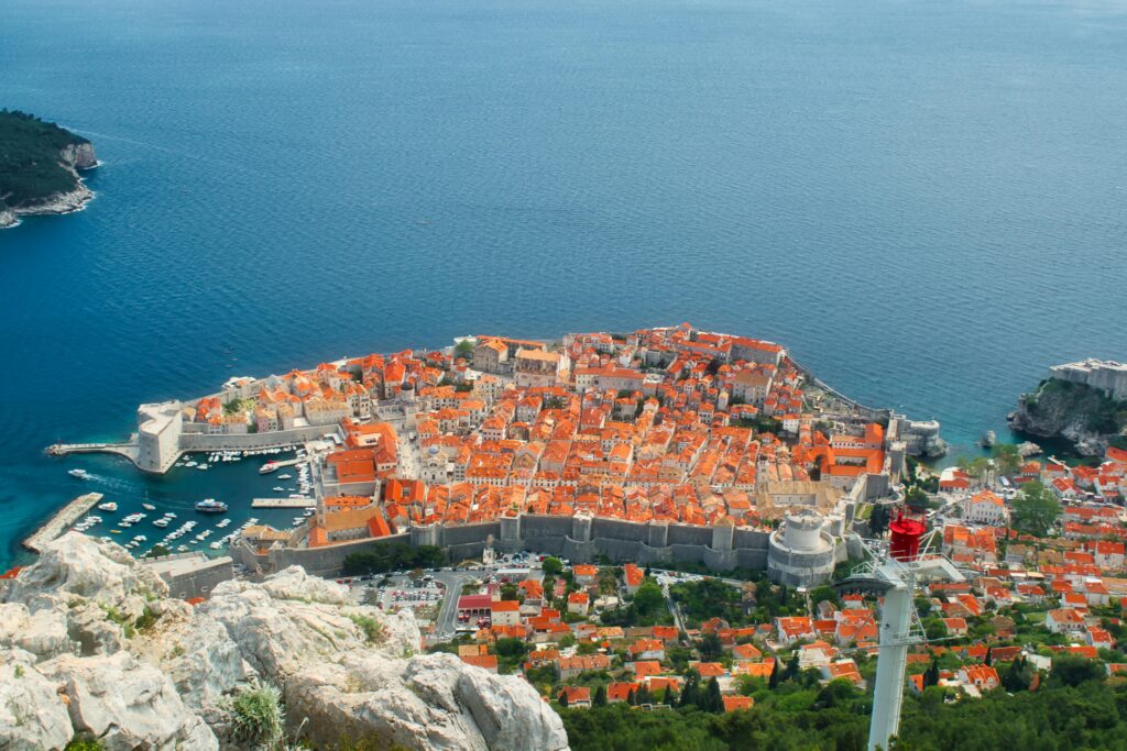 Best things to see in Dubrovnik, Croatia – panoramic view of the Old Town city walls with terracotta rooftops and Adriatic Sea in the background