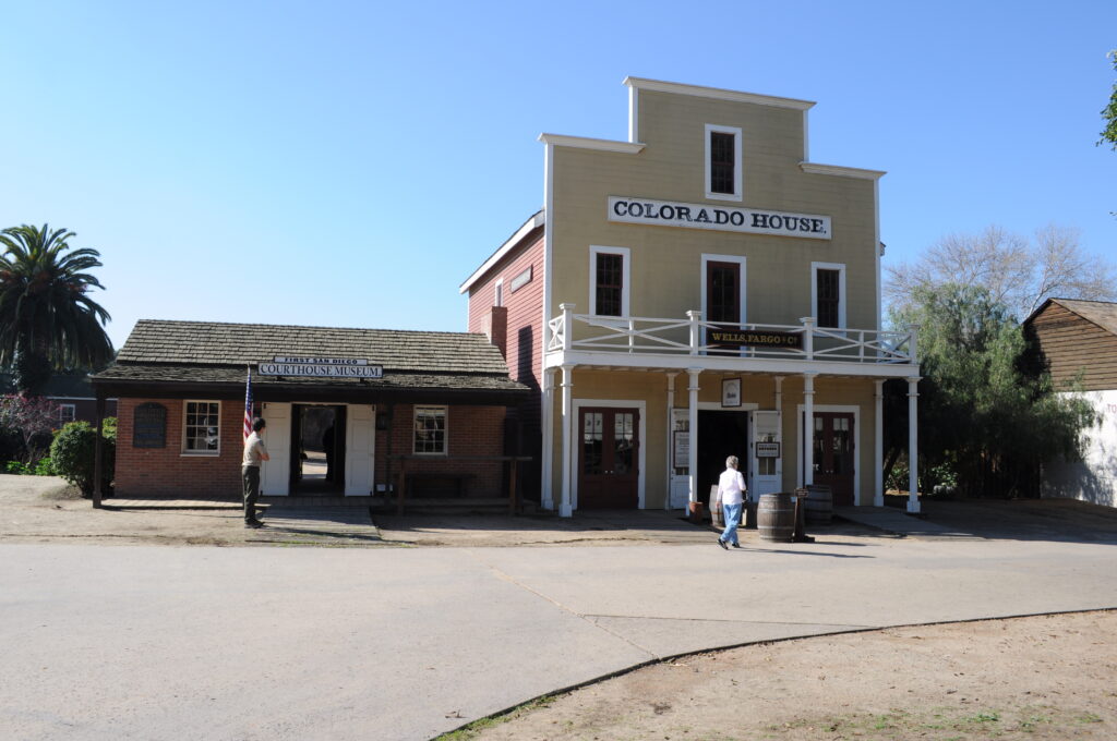 Historic adobe buildings and central courtyard at Old Town San Diego State Historic Park with visitors exploring