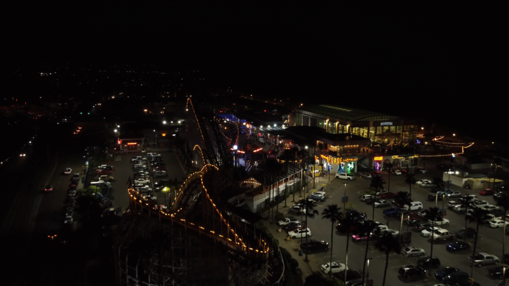 Belmont Park at night with glowing rides and boardwalk lights, showcasing fun things to do in San Diego at night.