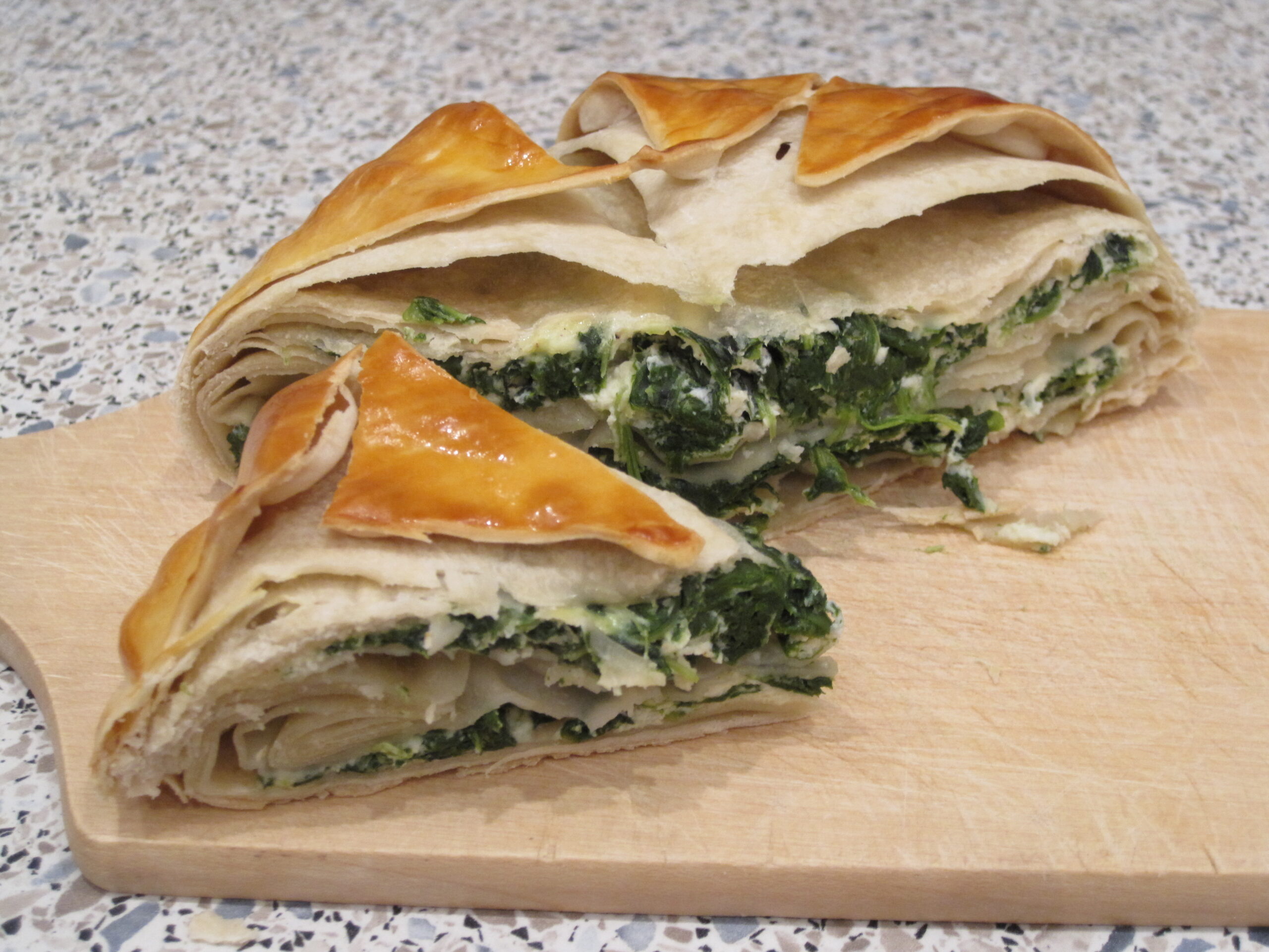 Greek spanakopita with buttery phyllo crust displayed at the Portland Maine Greek Festival food tent