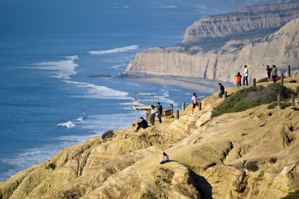 Hiker walking on scenic coastal cliff trail with panoramic Pacific Ocean views in San Diego California is free things to do in San Diego