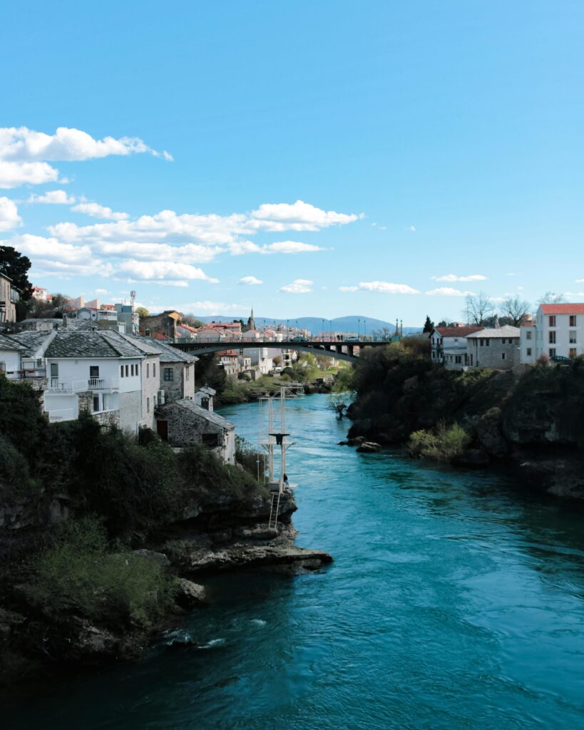 Scenic Neretva River bank in Mostar, Federation of Bosnia and Herzegovina, with views of the city’s old bridges and mountains