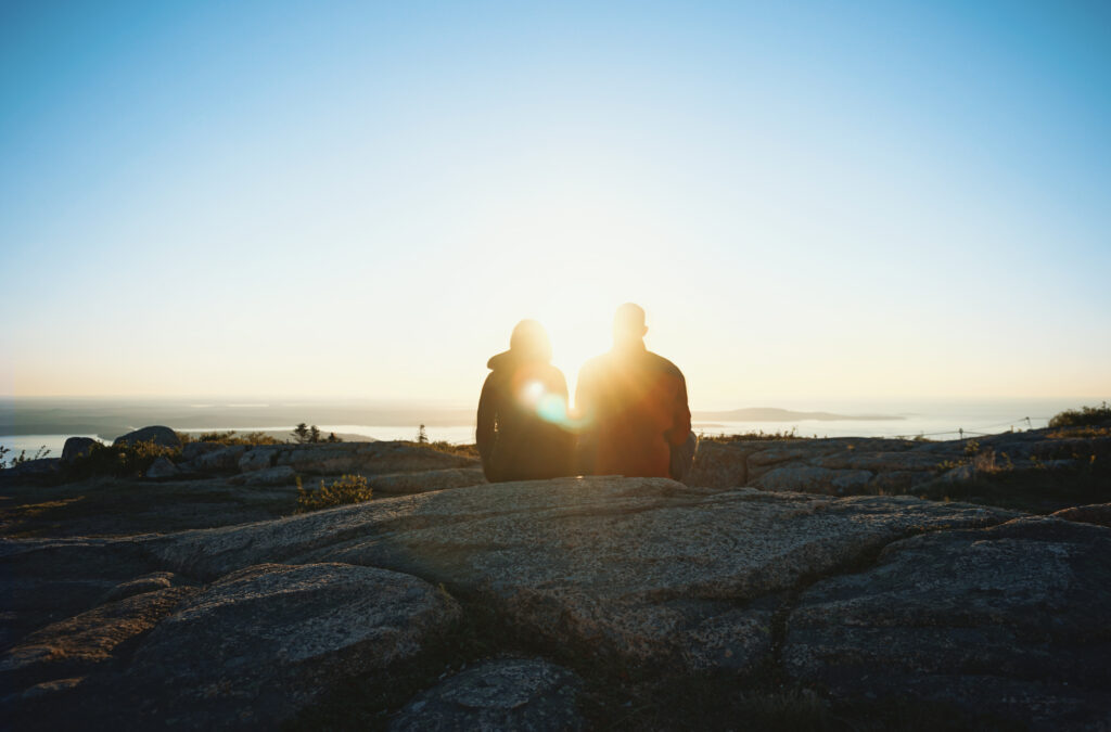 Visitors watching the sunrise from Cadillac Mountain, a must-do activity in Acadia National Park