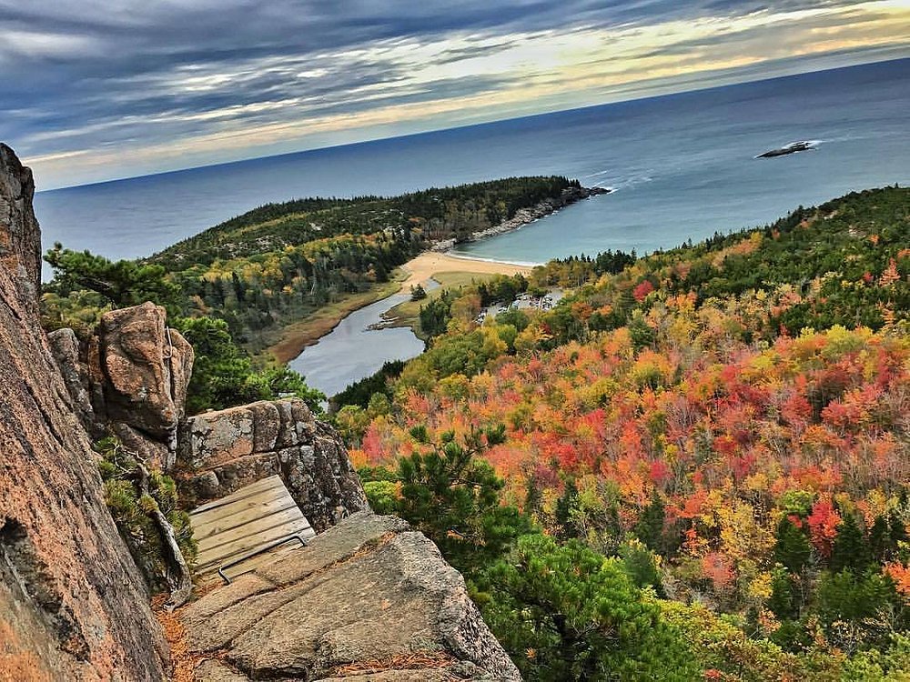 Scenic view of Beehive Trail overlooking Sand Beach and colorful fall foliage, highlighting adventurous hiking and top things to do in Acadia National Park, Maine