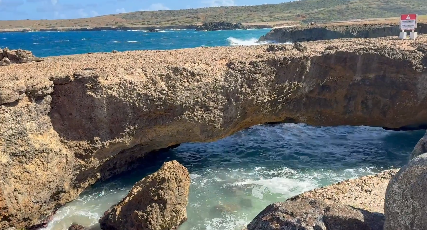 Close-up view of the Baby Natural Bridge Aruba with waves crashing beneath the limestone arch along the island’s rugged north coast.