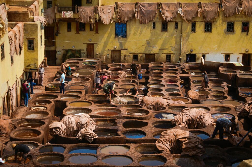 Traditional stone dye vats and workers at Chouara Tannery in Fes, Morocco