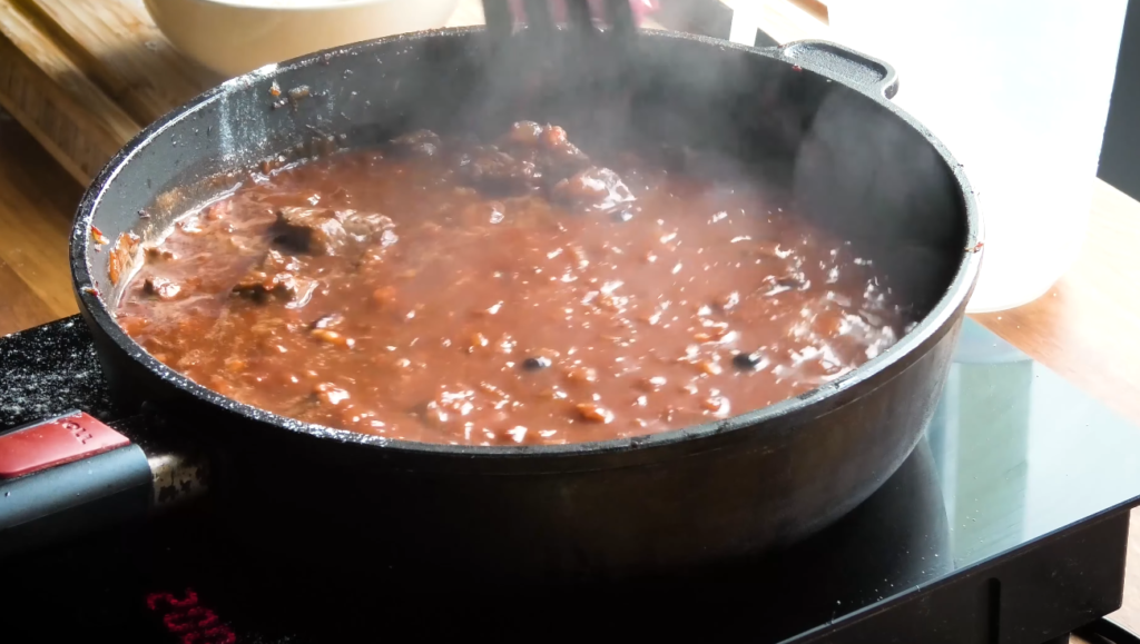 Pot of goulash simmering with steam rising and lid partially off of czech recipes goulash
