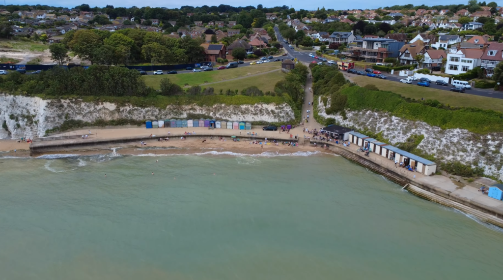 Dumpton Gap beach Broadstairs Kent showing golden sand colorful beach huts white chalk cliffs Blue Flag beach panoramic view