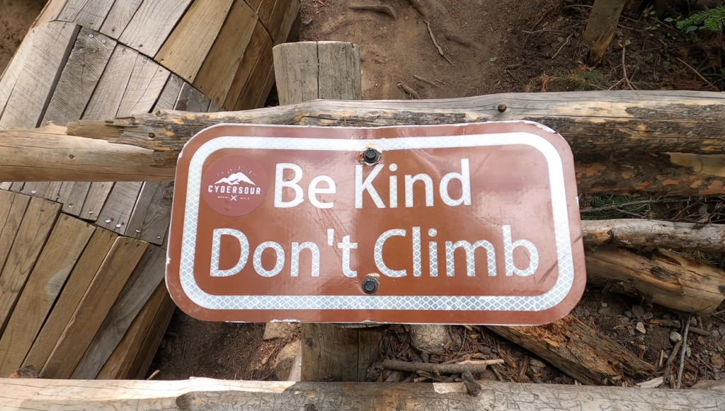 Be Kind Don’t Climb sign near the Breckenridge troll, highlighting the environmental message: why this troll matters and the importance of protecting nature