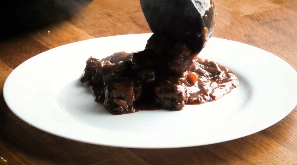 Finished Czech goulash in a bowl, thick gravy coating tender beef, garnished and ready to serve