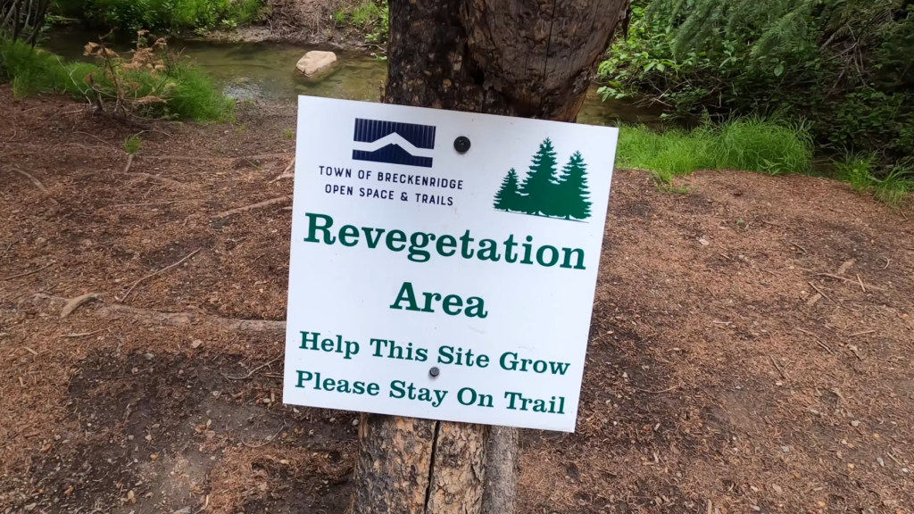 Revegetation area sign in Breckenridge near the Breckenridge Troll, reminding visitors how they can help protect the area by staying on designated trails