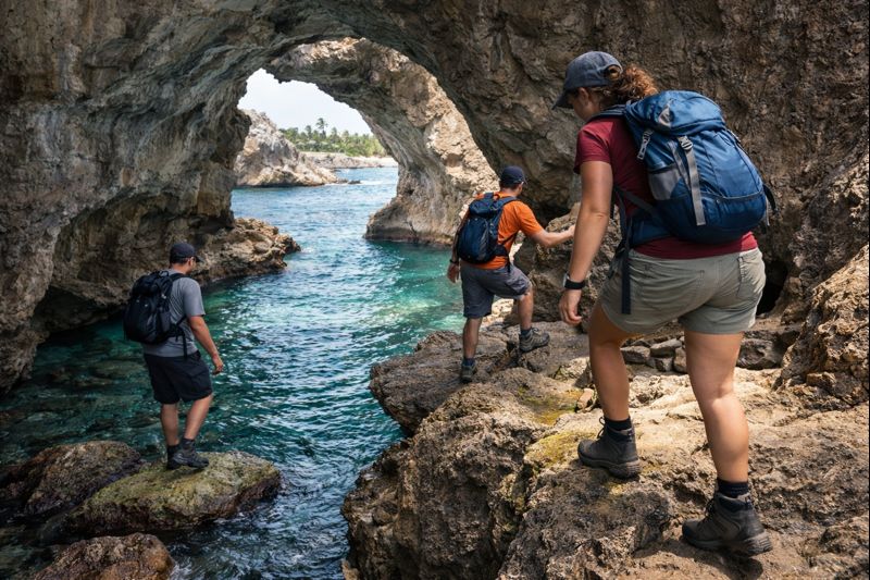 Hiker wearing proper sturdy shoes navigating rocky terrain at Cueva del Indio demonstrating safe cave exploration practices in Puerto Rico