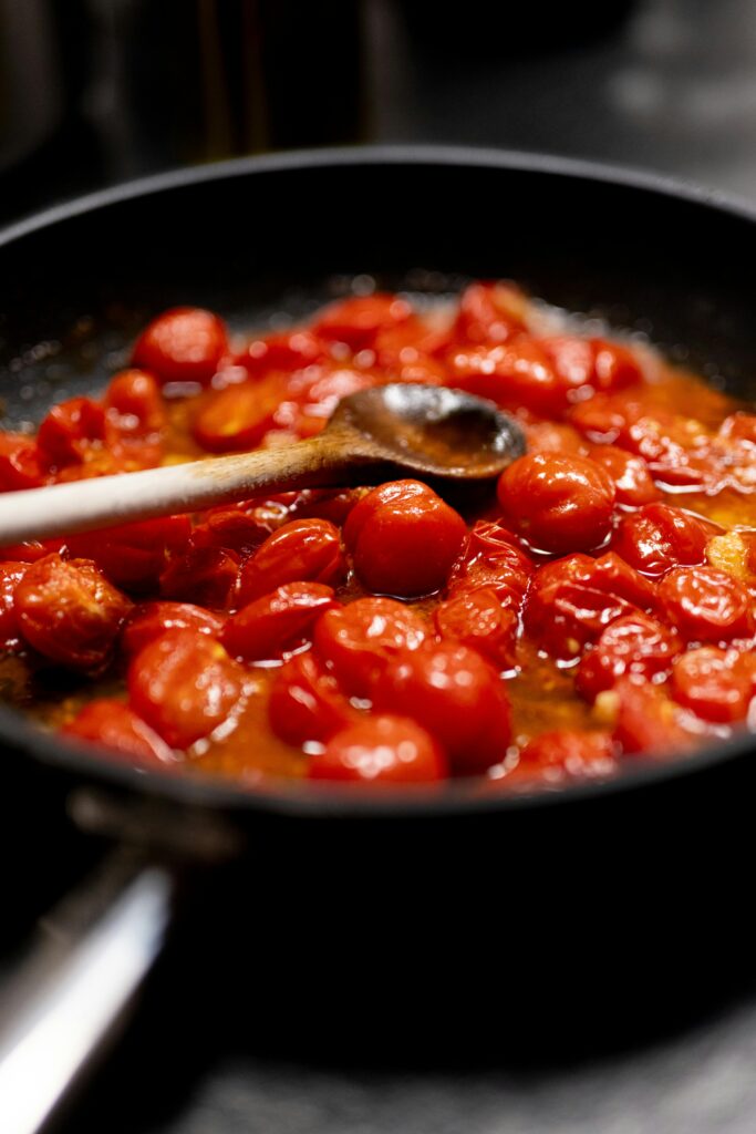 Spoon lifting thick goulash showing the rich, glossy texture of the sauce