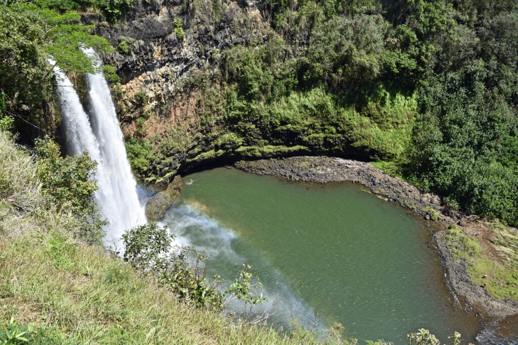 Waimea Falls (Waimea Valley) waterfall and pool surrounded by lush rainforest, one of the best hikes on Oahu