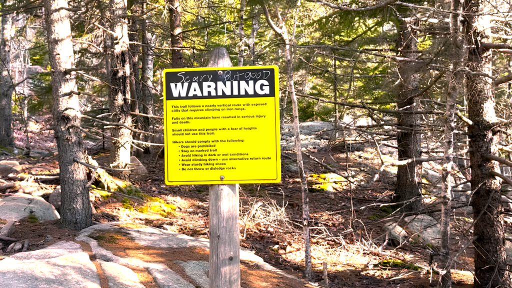 Beehive Trail warning sign about steep cliffs and ladder climbing in Acadia