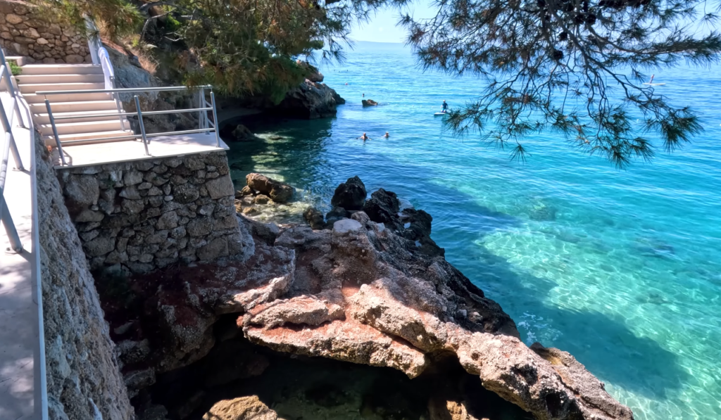 A scenic view of the sea from a cliff, showcasing the clear waters of Punta Rata Beach in Croatia.